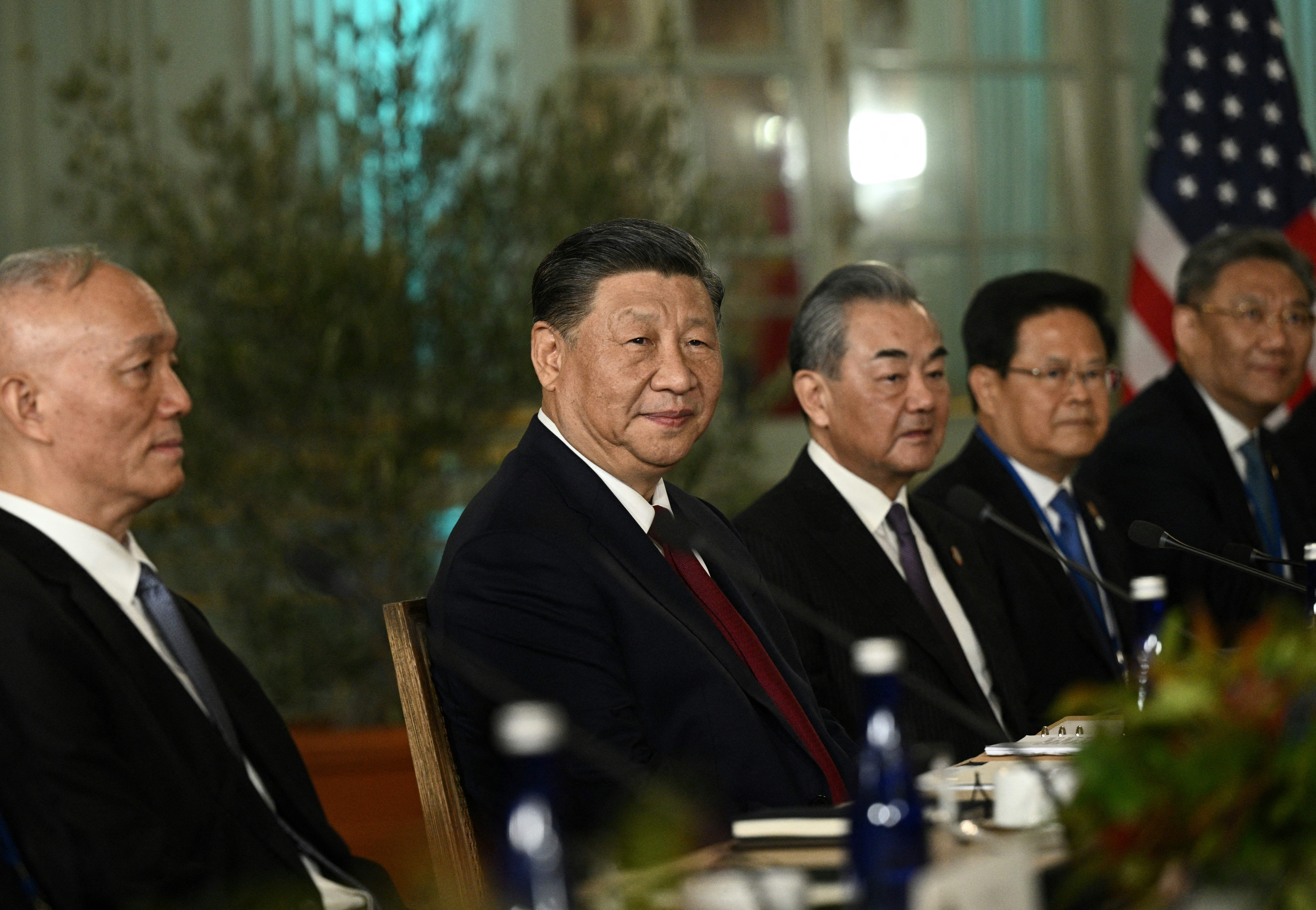 Chinese President Xi Jinping, Foreign Minister Wang Yi, and other Chinese officials sitting at meeting table